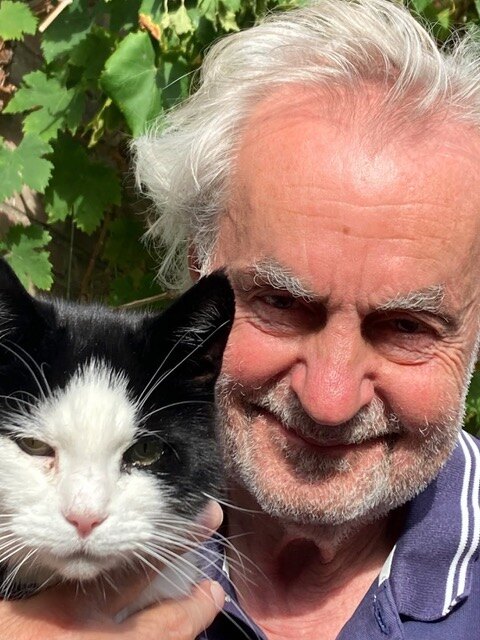 Roel van Duijn met zijn zwart-witte kat Krekel op zijn schouder